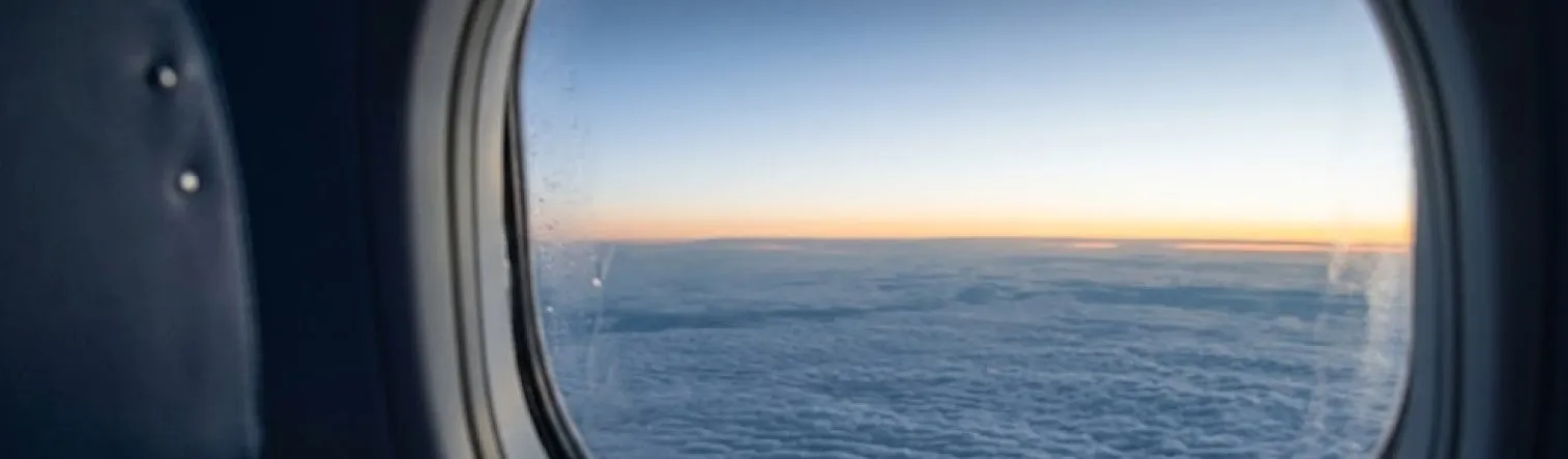 Mar de nuvens visto da janela de um avião ao amanhecer